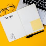 Home office desk workspace with laptop on yellow background. Flat lay, top view girl boss work business concept. Work at home concept on coronavirus quarantine