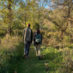 Students hiking a wooded trail together.