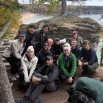 Group of students pose for picture next to wooded and water landscape along Picture Falls National Lakeshore